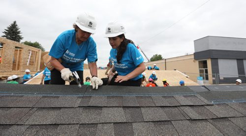 RUTH BONNEVILLE / WINNIPEG FREE PRESS

Photo of Kiran Kumar (right)  and her mom Renee working on shingling the roof of a home on Carter build site.  

The Kumar family, Teddy, his wife Renee and daughter Kiran from  Princeton New Jersey spend a week of their holidays volunteering their time to build homes for Habitat for Humanity at The Carter build site in St. James Tuesday.    Their daughter Kiran asked to volunteer for habitat  as her graduation gift .  Former U.S. president Jimmy Carter and his wife Rosalynn will help build homes on Thursday.  
July 11, 2017