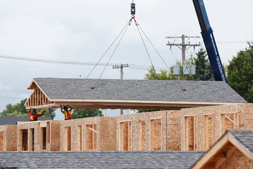 JOHN WOODS / WINNIPEG FREE PRESS
Construction crews raise the roofs on twenty homes at the Habitat For Humanity build on Lyle Street Tuesday, July 11, 2017.