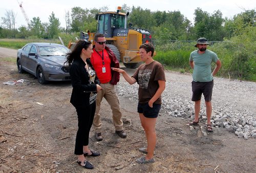 BORIS MINKEVICH / WINNIPEG FREE PRESS
Parker Lands development protestors are camped out on the development site to try to stop it. Police come to talk to protestors Jenna Vandal, middle, and Dirk Hoeppner, right. BEN WALDMAN STORY  July 17, 2017