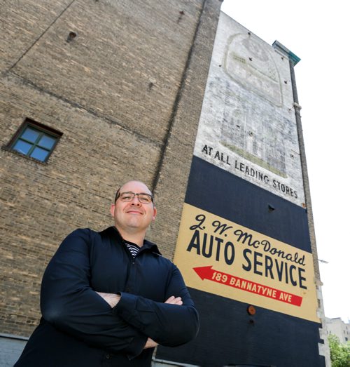 JUSTIN SAMANSKI-LANGILLE / WINNIPEG FREE PRESS
Matt Cohen poses in front of one of the building murals which will feature in several roof top events highlighting the city's faded "Ghost Signs." Cohen is organizing the event, which takes place July 29 and features large scale projections by Portland artist Craig Winslow.
170718 - Tuesday, July 18, 2017.
