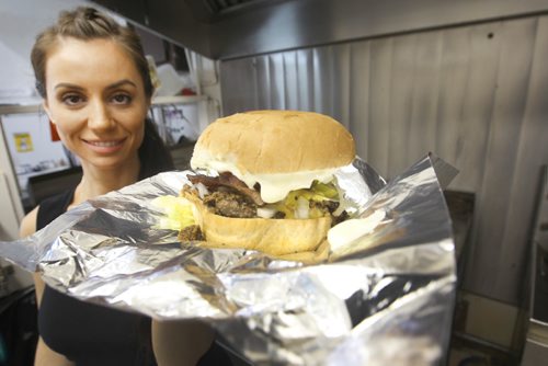 JOE BRYKSA / WINNIPEG FREE PRESS Vicky  Ramantanis from Vickys Dinner shows off the Vickys Favorite burger -  July 19 , 2017 -( See  Sanderson story)