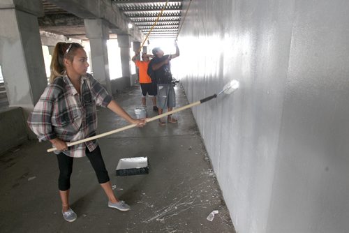 Two dozen volunteers including Madison Moar from the Point Douglas Residence Committee Green Team took part in painting the dark underpass near Main St and Higgins Ave white to brighten it up- Other volunteer groups included the Manitoba Metis Federation, Core Pride, and the North End Biz-Take Pride Winnipeg. The crews plan to return next week to finish the other side. -  July 20 , 2017 -( Standup Photo)