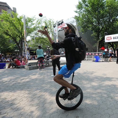 RUTH BONNEVILLE / WINNIPEG FREE PRESS

Daniel Both juggles while riding a unicycle for fun while at the 30th annual Fringe Festival in Market Square Thursday afternoon.  
Standup photo   
July 20, 2017