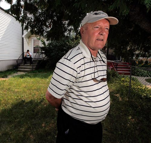 PHIL HOSSACK / WINNIPEG FREE PRESS  -  Jerry Wakshinski in front of the now vacant house where he and his seven other siblings grew up . And where his older brother died in August, was found by police in November but the family only learned was dead and buried when they received a letter from the city in late June asking to gain entry to the derelict house. His nephew Todd Webster sits on the steps behind him. Gord Sinclair story. -  July 20, 2017