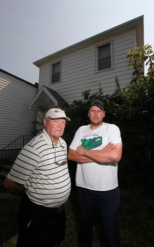 PHIL HOSSACK / WINNIPEG FREE PRESS  -  Jerry Wakshinski (left) and his nephew Todd Webster in front of the now vacant house where Jerry and his seven other siblings grew up . ...And where his older brother died in August, was found by police in November but the family only learned was dead and buried when they received a letter from the city in late June asking to gain entry to the derelict house. Gord Sinclair story. -  July 20, 2017