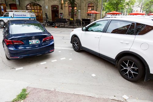 JUSTIN SAMANSKI-LANGILLE / WINNIPEG FREE PRESS
A row of cars demonstrate the new angled parking spots on Bannatyne Ave. Friday. The changes to street parking will increase the total parking spots in the area by 10.
170721 - Friday, July 21, 2017.