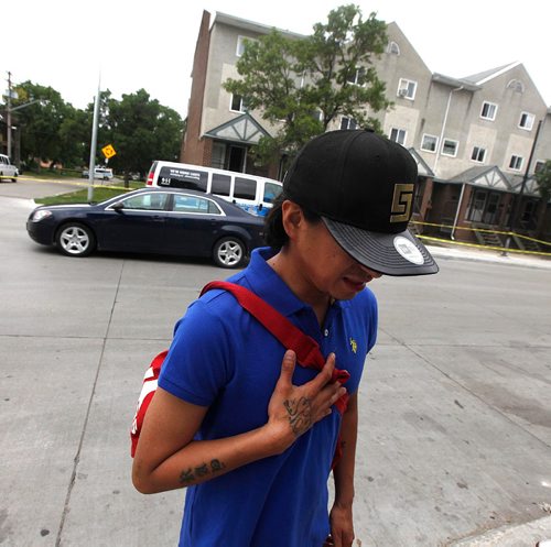 PHIL HOSSACK / WINNIPEG FREE PRESS  -  Sporting a gang tattoo (Bloods) on his hand Raymond, a neighborhood witness talks to Melissa Saturday as Police investigators work the scene of a shooting/homicide at 101-740 Selkirk Ave Saturday morning. See melissa Martin's story.   -  July 22, 2017