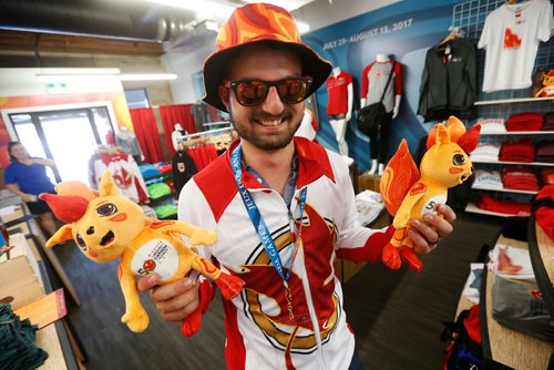 JOHN WOODS / WINNIPEG FREE PRESS
Micheal Reimer, with Niibin in hand, tries on some of his favourite Canada Games gear at Canada Games store at the Forks in Winnipeg Monday, July 24, 2017