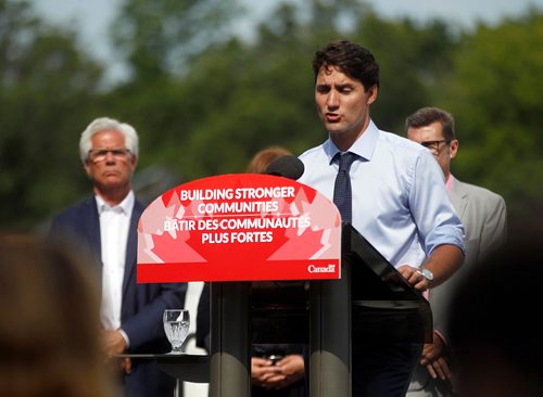 PHIL HOSSACK / WINNIPEG FREE PRESS  -  .PM Justin Trudeau speaks at a tour the future site of Diversity Gardens Saturday Morning, Mb Ministyer Jim Carr stands rear left. .  -  July 29, 2017