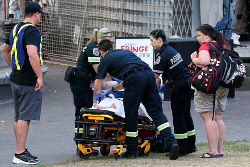 JOHN WOODS / WINNIPEG FREE PRESS
A woman is taken away by paramedics after collapsing due to heat at the Fringe main stage Sunday, July 30, 2017.