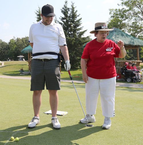 JASON HALSTEAD / WINNIPEG FREE PRESS

Gail Smidt (chairperson of the SMD Alliance board and board member of the SMD Foundation board), right, helps Stephen Gnutel prepare for the one-armed putting contest at the Brett Poncelet and La Salle Insurance and Travel Ltd. seventh annual Charity Golf Tournament in support of the Society for Manitobans with Disabilities (SMD) Foundation/Easter Seals Manitoba at Kingswood Golf and Country Club on July 26, 2017.(See Social Page)