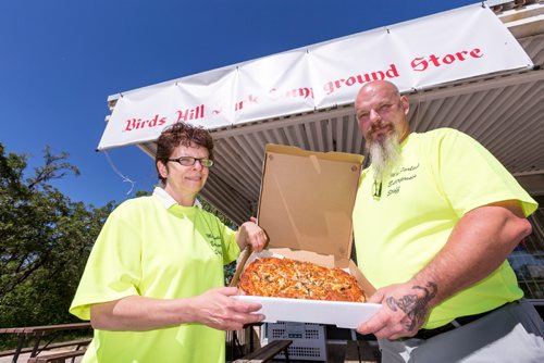 JUSTIN SAMANSKI-LANGILLE / WINNIPEG FREE PRESS
Jackie and Larry MacFarlane pose with a pizza Thursday at the Birds Hill Park campground store. The couple have started making and delivering pizzas to campers since they took over the property.
170803 - Thursday, August 03, 2017.