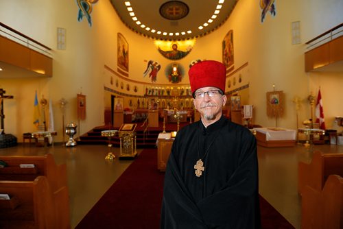 JUSTIN SAMANSKI-LANGILLE / WINNIPEG FREE PRESS
Rev. Eugene Maximiuk of Holy Trinity Ukrainian Orthodox Metropolitan Cathedral poses in front of the altar and the cathedral's restored icon paintings Friday.
170804 - Friday, August 04, 2017.