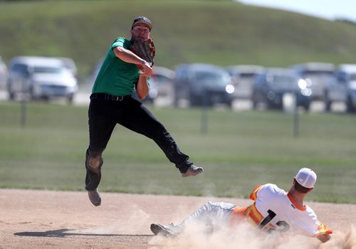 TREVOR HAGAN / WINNIPEG FREE PRESS
Garrett Pawluk, of the Pitch Slappers, from Abbotsford, BC, tries to turn a double play as Conrad Funk, of the Prides Thunder from Swift Current, Saskatchewan, tries to run to second base during Slow Pitch Nationals at Little Mountain Sportsplex, Sunday, August 6, 2017.