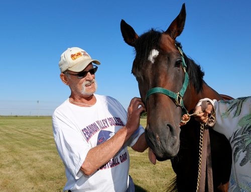 JUSTIN SAMANSKI-LANGILLE / WINNIPEG FREE PRESS
Owner Brian Smith poses with his racehorse Kenny Do The Math outside the Assiniboia Downs stables Thursday.
170810 - Thursday, August 10, 2017.