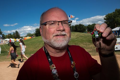 MIKE DEAL / WINNIPEG FREE PRESS
Barry Taman with The Pin People holds up one of the very sought after pins his company makes for events like the Canada Summer Games. He has a table at The Forks where you can purchase some of the dozens of pins his company produces..
170810 - Thursday, August 10, 2017.