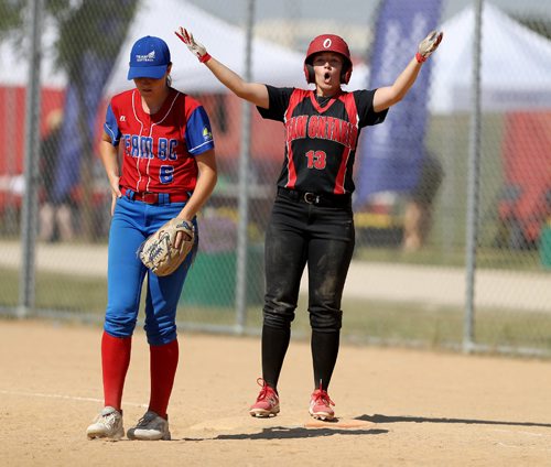 TREVOR HAGAN / WINNIPEG FREE PRESS
Team Ontario's Hannah McClounie, gestures to her bench after reaching first base as BC's Danielle de Ruiter looks on, during their softball game at John Blumberg, Saturday, August 12, 2017.