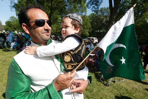 JOHN WOODS / WINNIPEG FREE PRESS
Jehangir Khan and son Ibrahim dressed in traditional clothing from the province of Khyber Pakhtun Khuwan wave their flag at a 70th anniversary celebration of Pakistan independence at St Vital Park Sunday, August 13, 2017.