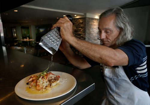WAYNE GLOWACKI / WINNIPEG FREE PRESS
Sunday Special/This City
.. La Scala restaurant owner Perry Scaletta grates parmesan cheese on the Seafood Mixed Grill. David Sanderson story. August 16 2017