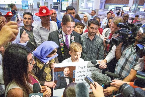 JUSTIN SAMANSKI-LANGILLE / WINNIPEG FREE PRESS
Emad Mishko Tamo, 12 and his family move through a large crowd of supporters and media at Winnipeg's James Armstrong Richardson International Airport Thursday after being re-united.
170817 - Thursday, August 17, 2017.