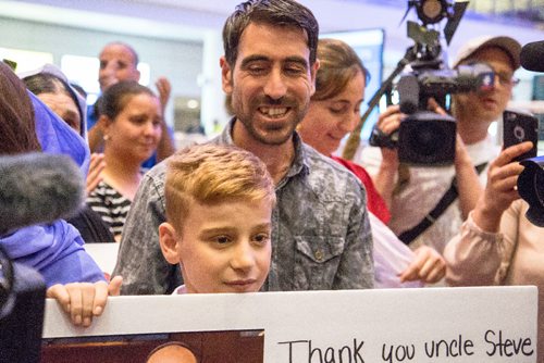 JUSTIN SAMANSKI-LANGILLE / WINNIPEG FREE PRESS
Emad Mishko Tamo, 12 and his uncle Hadji Tamo move through a large crowd of supporters and media at Winnipeg's James Armstrong Richardson International Airport Thursday after Emad was re-united with his family after being freed from ISIS captivity and returned to his family in Winnipeg.
170817 - Thursday, August 17, 2017.