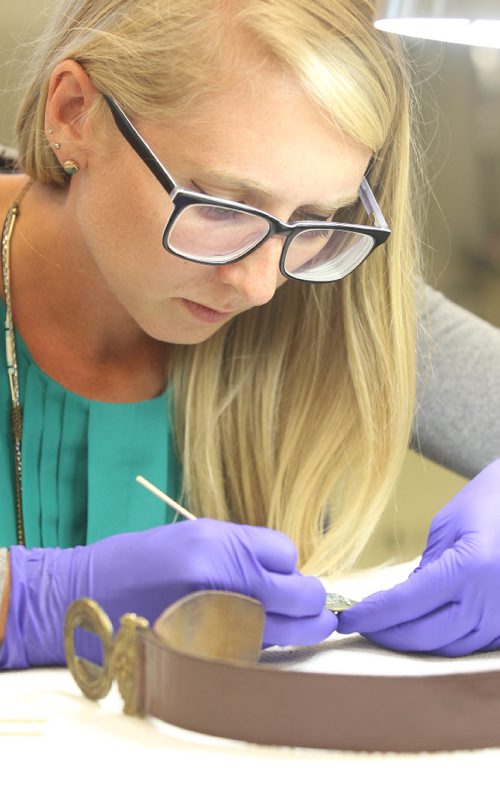 JOE BRYKSA / WINNIPEG FREE PRESS Manitoba Museums Carolyn Sirett, Conservator with  WWII leather uniform belt with copper-alloy buckle. Aug 15, 2017 -( See Melissa Martins 49.8 story  story)