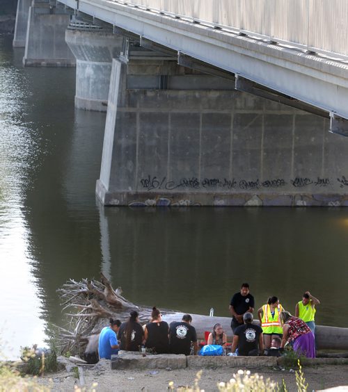 WAYNE GLOWACKI / WINNIPEG FREE PRESS

Family and community members along with Drag The Red and Bear Clan members gathered underneath the Harry Lazarenko Bridge Friday afternoon after a body was recovered and pulled out of the Red River near St. John's Park. August 18 2017