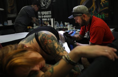 
Tattooer Brian Carr of New Tribe Tattoos, works on a tattoo on the leg of Chloe Lippens  at the inaugural Winnipeg Tattoo Convention Saturday, on all weekend,  at Red River Exhibition Park. The three-day event is billed as a "celebration of tattoo art, culture, craftsmanship and self-expression and features more than 200 artists.

Aug 19, 2017