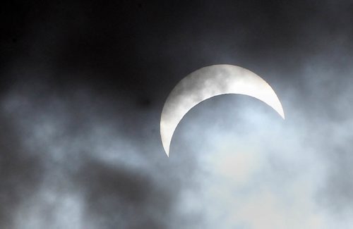 JOE BRYKSA / WINNIPEG FREE PRESSThe moon covers about 70 percent of the sun at 1PM during a partial eclipse for a few quick seconds as clouds broke over Winnipeg Monday.Aug 21, 2017 -( Standup photo)