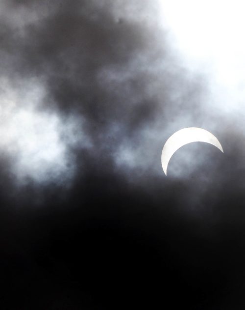 JOE BRYKSA / WINNIPEG FREE PRESSThe moon covers about 70 percent of the sun at 1PM during a partial eclipse for a few quick seconds as clouds broke over Winnipeg Monday.Aug 21, 2017 -( Standup photo)