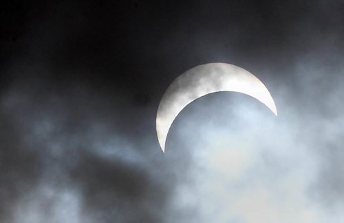 JOE BRYKSA / WINNIPEG FREE PRESSThe moon covers about 70 percent of the sun at 1PM during a partial eclipse for a few quick seconds as clouds broke over Winnipeg Monday.Aug 21, 2017 -( Standup photo)