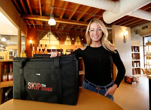 JUSTIN SAMANSKI-LANGILLE / WINNIPEG FREE PRESS
Skip the Dishes Director of Marketing Kendall Bishop poses with one of the company's delivery bags Tuesday inside Elements fine wines. The food delivery service will begin delivering wine, beer and spirits to customer's doors alongside the current food offerings.
170822 - Tuesday, August 22, 2017.