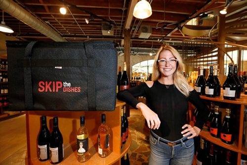 JUSTIN SAMANSKI-LANGILLE / WINNIPEG FREE PRESS
Skip the Dishes Director of Marketing Kendall Bishop poses with one of the company's delivery bags Tuesday inside Elements fine wines. The food delivery service will begin delivering wine, beer and spirits to customer's doors alongside the current food offerings.
170822 - Tuesday, August 22, 2017.