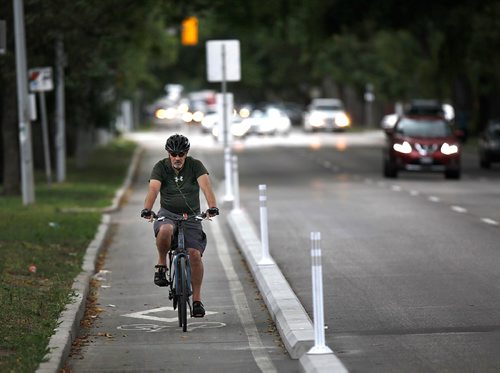 PHIL HOSSACK / WINNIPEG FREE PRESS  -  A cyclist makes his way up Sherbrook Street behind a short strip of protective curbs. - Aldo Santin story. - August 22, 2017