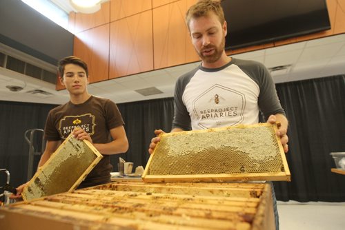 JOE BRYKSA / WINNIPEG FREE PRESS Chris Kirouac from Beeproject Apiares, right ( BA) and  Lucas Smith   make off beehive frames that were gathered from the rooftop of Red River College ( RRC) Notre dame. Staff and students were given the demonstration of harvesting to see firsthand how the finished product, honey, is collected from their hives.  RRC and BA doubled their 2nd year roof top beehives to six hives this year and hope to produce 150 kilograms of honey this season. RRC and BA hope to sell the honey to staff and students on campus. Aug 23, 2017 -(Redekop story)