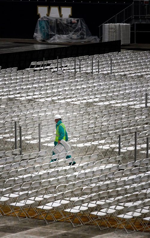 PHIL HOSSACK / WINNIPEG FREE PRESS  - A laborer sets up chairs as the Guns n' Roses stage rises in the Investor's Group Field Wednesday afternoon. One of three, the stage takes three days to build and thirty trucks to transport it and the pyrotechnics and gear associated with the world tour. Up to 1100 local people are often hired at each stop, from paramedics to cooks to laborers.  - August 23, 2017