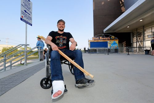 JUSTIN SAMANSKI-LANGILLE / WINNIPEG FREE PRESS
Lee Krunek sits outside Investors Group Field Thursday as he waits to get in for the Guns N' Roses concert. Krunek broke his ankle on Saturday and refused to let the 6 pins in his foot stop him from attending the concert. 
170824 - Thursday, August 24, 2017.
