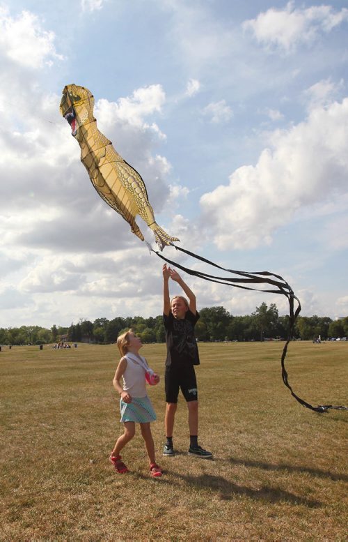 RUTH BONNEVILLE / WINNIPEG FREE PRESS 

 Alaina McLaren (5yrs) and her brother Cass (9yrs) reach up high to release a  large dinosaur kite on windy Friday afternoon. 

Standup photo
Aug 24, 2017
