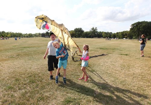 RUTH BONNEVILLE / WINNIPEG FREE PRESS 

 Simon MCLaren (7yrs) his sited Alaina (5yrs) friend Callum Campbell (11yrs) reach up high to release a  large dinosaur kite on windy Friday afternoon. The kite was a gift for Simon (blue) who just turned ors years last week.  

Standup photo
Aug 24, 2017
