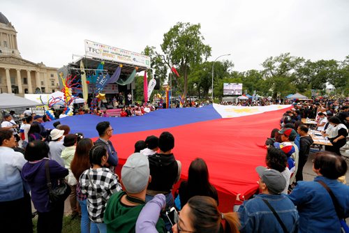 JUSTIN SAMANSKI-LANGILLE / WINNIPEG FREE PRESS
Spectators and organizers join forces to hold up a giant Filipino flag Saturday during the Filipino Street Festival.
170826 - Saturday, August 26, 2017.