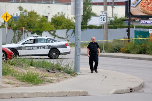 JUSTIN SAMANSKI-LANGILLE / WINNIPEG FREE PRESS
A Winnipeg Police Officer walks towards the intersection of Arlington and Logan Saturday. Police say a cyclist was hit by a vehicle near the intersection of Logan and Arlington before 11am.
170826 - Saturday, August 26, 2017.