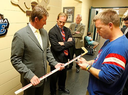 BORIS MINKEVICH / WINNIPEG FREE PRESS  080924 Wayne Gretzky checks out an old autographed Titan hockey stick that Geoff Kirbyson his grandfather had. Kirbyson's kid Alex was there too.