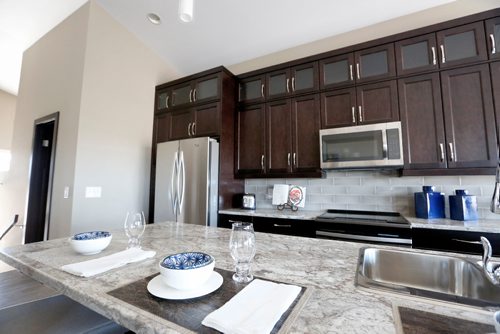 JUSTIN SAMANSKI-LANGILLE / WINNIPEG FREE PRESS
The kitchen of 64 Eaglewood shares the same high ceilings and abundance of natural light as the living room as well as modern appliances and a large island.
170828 - Monday, August 28, 2017.
