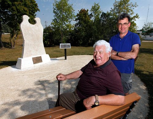 PHIL HOSSACK / WINNIPEG FREE PRESS  - Former City Counselor and Elder with the Union Nationale Metisse, Guy Savoie (sitting) and sitting City counselor Brian Mayes pose beside a re positioned and rejuvinated statue commemorating Louis Riel near St Annes Rd and Meadow wood ave. See Aldo Santin's story. - August 29, 2017