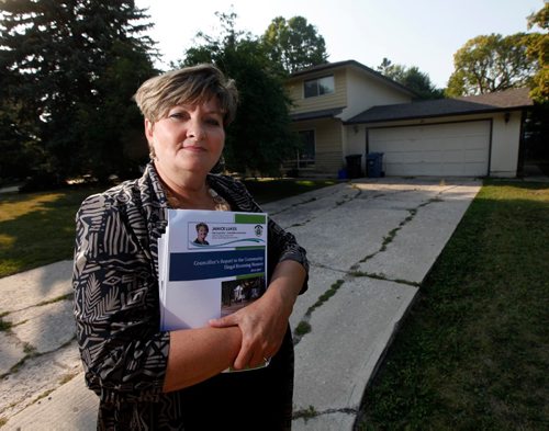 PHIL HOSSACK / WINNIPEG FREE PRESS  -  City Counsilor Janice Lukes stands in front of a Thatcher Drive house used as an illegal rooming house Wednesday evening. She's holding a report to be released Thursday on the issue.  See story - August 30, 2017