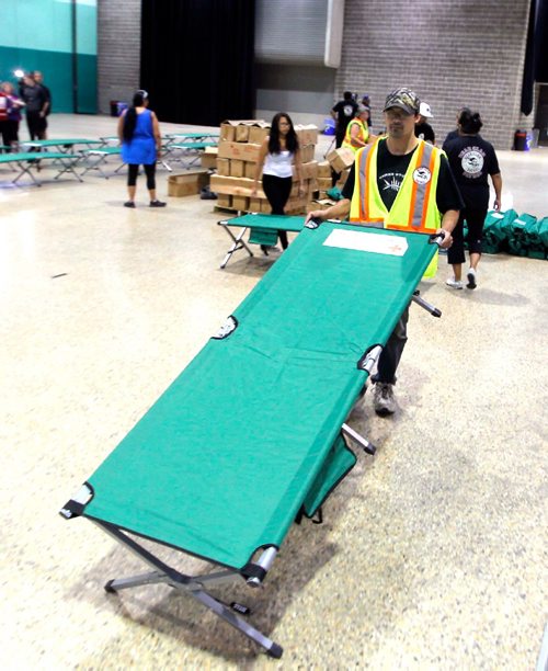 BORIS MINKEVICH / WINNIPEG FREE PRESS
Red Cross volunteer from the Bear Clan patrol David Fehr sets up some cots in the RBC Convention Centre. The first bus loads of forest fire evacuees from Garden Hill northern MB arrived at the RBC Convention Centre this morning. BEN WALDMAN STORY. August 31, 2017