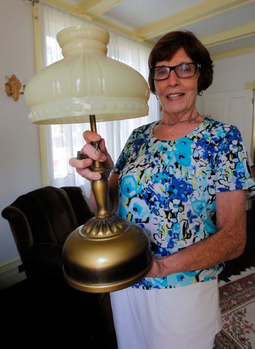 BORIS MINKEVICH / WINNIPEG FREE PRESS
Manitou, MB - Nellie McClung buildings and exhibit. The buildings have been repaired and moved back to Manitou, MB. The town has made a special place for them with new sidewalks to access the buildings. Here Bette Mueller holds a lamp that McClung once used. BILL REDEKOP STORY. August 30, 2017