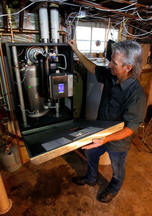 BORIS MINKEVICH / WINNIPEG FREE PRESS
Winnipeg, MB - Homes - Robert Boulet is the owner/operator of Priority Plumbing & Heating Ltd. Here is a shot of Boulet and a new boiler at a Westgate home. Sept. 1, 2017