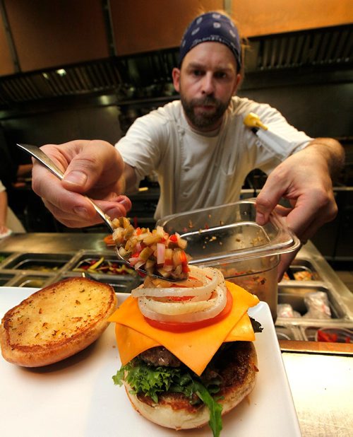 PHIL HOSSACK / WINNIPEG FREE PRESS  -  STAND UP - Barley Brothers Chef Lorne Giesbrecht puts the finishing touches on the establishemnt's "We Draughted Caesar" burger. Their sandwich designed around Le Burger Week. See below.  - Sept 1, 2017

Le Burger Week kicks off today. 
Barley Brothers entry...

"We Draughted Caesar"

Inspired by our Barley Caesar, this bison burger is just the right combination of flavours. You will taste a beer inspired Caesar in every bite. The patty is topped with local old cheddar cheese, our made-in-house Clamato relish, beer mustard, beer and bacon jam, market fresh tomatoes, onions and leaf lettuce. No Caesar is complete without celery salt found rimmed on our brioche bun and of course garnished to the T! 

