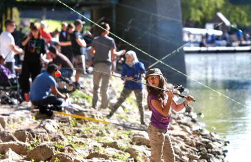 WAYNE GLOWACKI / WINNIPEG FREE PRESS

Kylie Calvez,10, checks her line before casting into the Assiniboine River Saturday morning. Kylie and her family were among the over 300 anglers taking part in the 15th annual fishing derby held along the shore at The Forks in support of Never Alone Foundation and Marymound School. 
  Sept. 2 2017